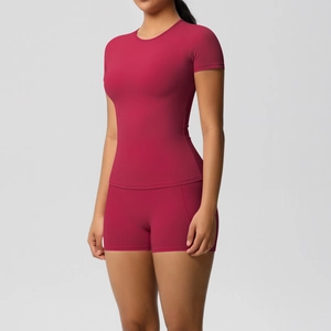 Detail of rose red nylon yoga set showing high-waisted shorts and fitted short sleeve top