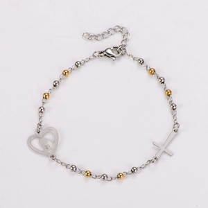 Detail of silver and gold beaded bracelet with heart icon and cross pendant charms