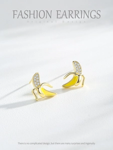 Close-up of S925 silver banana earrings with yellow enamel and micro-pave crystals