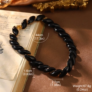 Detail view of 44cm black glossy twist chain necklace with gold edges on vintage book