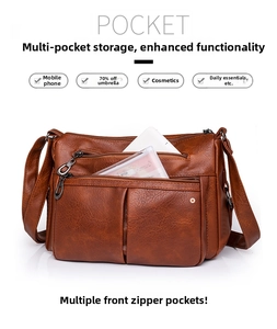 Brown leather crossbody bag detail showing multiple functional pockets and large capacity
