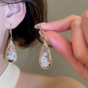 Elegantes pendientes hechos a mano de gota con flores blancas secas en resina clara