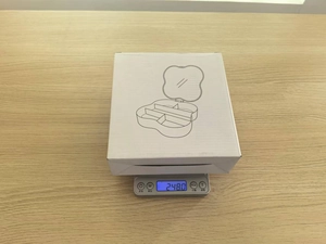 White packaging box for four-leaf clover jewelry storage box weighing 248 grams on scale