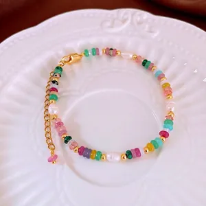 Bracelet de perles style New Chinese avec pierres naturelles et perles dorées sur plat blanc