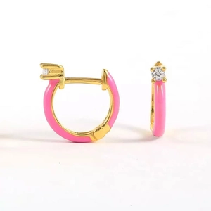 Detail view of gold hoop earrings with bright pink enamel and sparkling zircon stone