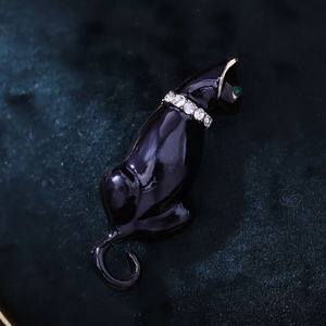 Macro detail of black enamel panther brooch with crystal collar and green gemstone eye