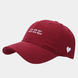 Detail of burgundy cotton baseball cap with white embroidery and heart side logo