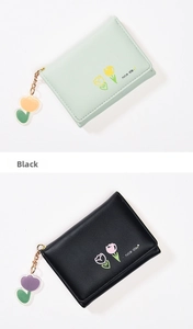 Detail of short wallets in mint green and black with tulip print and floral charms