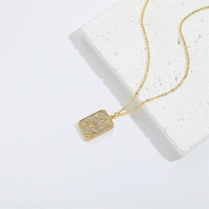 Minimalist gold necklace with a diamond-encrusted lucky symbol pendant on white stone