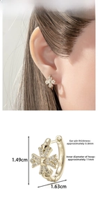 Macro detail of gold cross hoop earring with cubic zirconia and size specifications