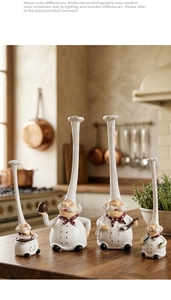 Detail view of four resin chef figurines with long hats on a wooden kitchen countertop