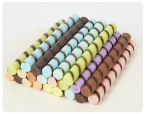 Macro detail of colorful PVC chocolate sticks with spiral patterns in macaron tones