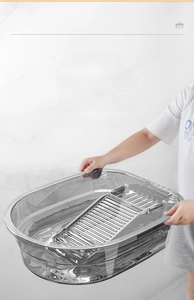 Gros plan d'une bassine à linge transparente avec planche à laver et poignées larges