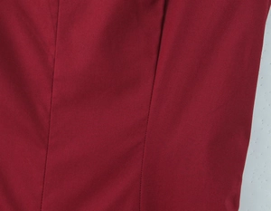 Détail de la texture du tissu rouge et des coutures de qualité sur la robe avec laçage au dos