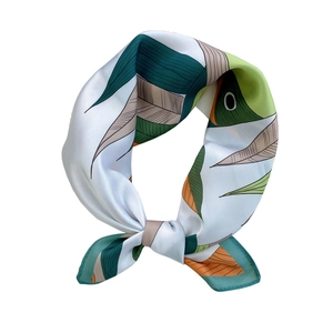 Elegant silk scarf featuring abstract green and orange leaf patterns on white