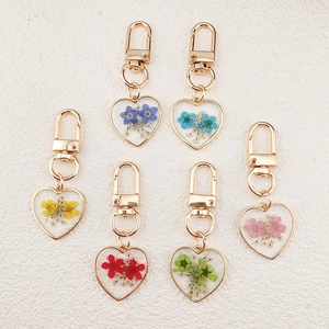 Set of 6 heart-shaped pressed flower keychains with gold frames in assorted colors