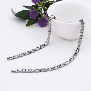 Macro view of polished silver-colored rectangular link chain necklace in stainless steel