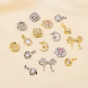 Macro shot of assorted gold and silver clover and star pendants with pink zircon crystals