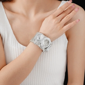 Detail of silver multi-layer woven wire open cuff bracelet with spiral metal texture