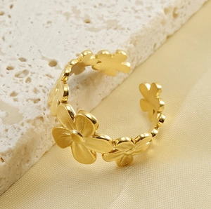 Vista de detalle del anillo ajustable con diseño floral en acero chapado en oro 18k