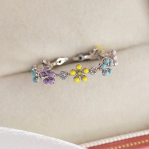 Close-up of macaron flower ring with colorful enamel petals and sparkling zircon stones