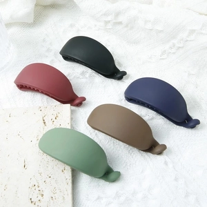 Set of five matte banana hair clips in various colors displayed on a neutral stone surface