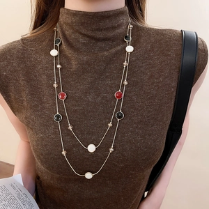 Détail d'un collier vintage à double rang avec perles en résine et chaîne dorée