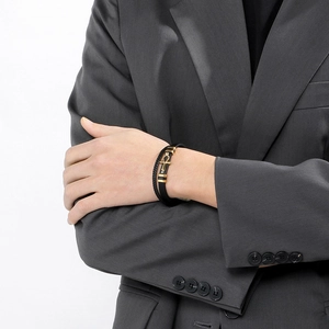 Detail of multi-layer leather bracelet with golden Ankh cross on a male model's wrist
