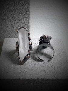 Macro shot of white natural crystal point and textured bronze adjustable open ring