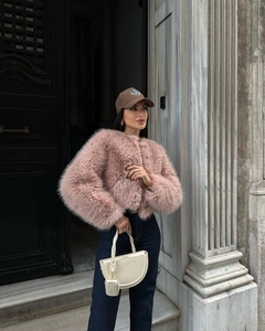 Dettaglio della trama di una giacca corta in ecopelliccia rosa in uno scatto street style
