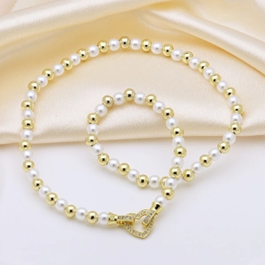 Elegant natural pearl necklace with golden beads and heart-shaped rhinestone clasp