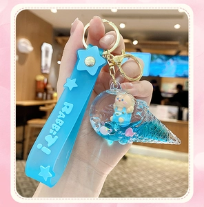Close-up of blue ice cream liquid glitter keychain with floating rabbit and strap