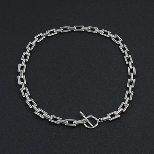 Close-up of polished stainless steel chain links with minimalist OT toggle clasp