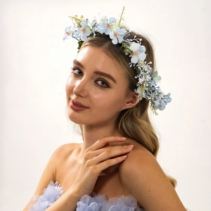 Blue handmade floral crown headband featuring fabric roses and leaves on a female model