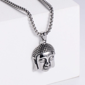 Detail of vintage stainless steel Buddha head pendant with textured finish on box chain