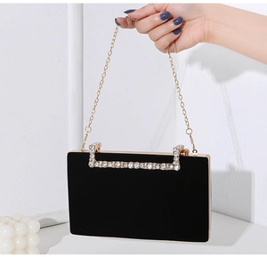 Detailansicht einer schwarzen Samt-Abendtasche mit Strassverzierung und Goldkette