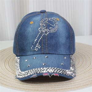 Détail d'une casquette de baseball en jean avec strass brillants et rivets métalliques
