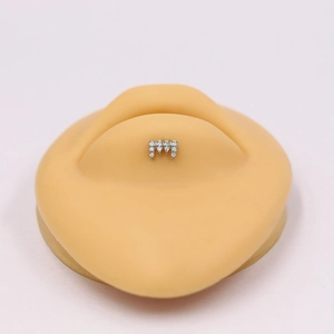 Detailed close-up of a silver wave cartilage stud with diamonds on a silicone ear model