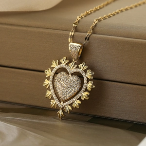Elegante goldene Herz-Halskette mit Zirkonia-Steinen auf braunem Lederhintergrund