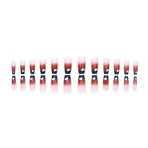 French gradient press-on nails in reddish-brown with white heart patterns