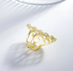 Macro detail of gold-plated hollow triangle mesh ring with sparkling zircon inlay