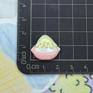 Detailed macro view of 2cm resin shaved ice charm on a black measurement cutting mat