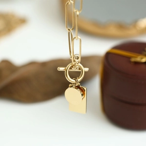 Gold paperclip chain necklace with toggle clasp and geometric round and square pendants