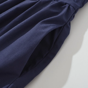 Close-up of navy blue dress showing fabric texture and side pocket design detail