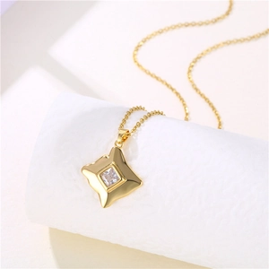 Close-up of golden square pendant necklace with clear zircon stone on white background