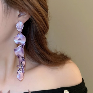 Detailed close-up of long purple gradient petal tassel earrings worn by a model