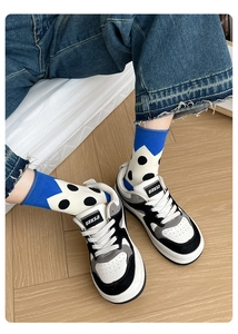 Detail of rolled cuff polka dot socks with URYSA sneakers and denim jeans