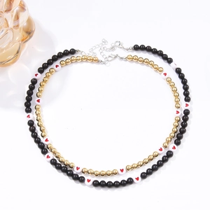 Detailed shot of black and gold beaded necklaces with red heart patterns for Christmas