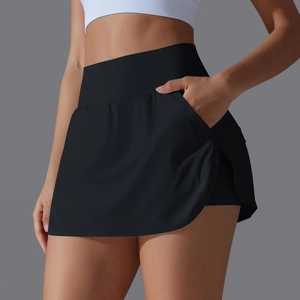Detail view of high-waisted black tennis skort with side pocket and pleated curved hem