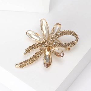 Macro detail of golden flower brooch with champagne crystals and sparkling rhinestones